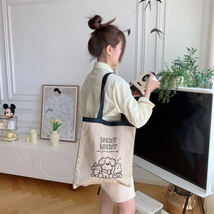 Detailed embroidery on light beige canvas tote bag with cute cartoon dog illustrations