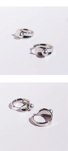 Detailed close-up of a silver-toned earring hoop featuring a gray pearl bead design