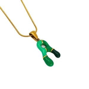 Collana con ciondolo a lettera colorata in smalto verde su una sottile catena dorata