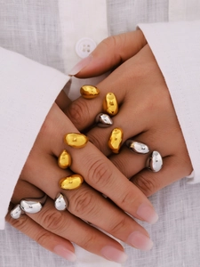 Close-up of gold and silver teardrop rings styled together on a model's hand