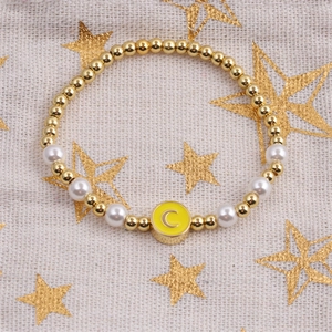 Beaded bracelet with gold beads, white pearls and a yellow letter C enamel charm