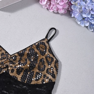 Détail d'un caraco à imprimé léopard avec paillettes noires et bordure en dentelle