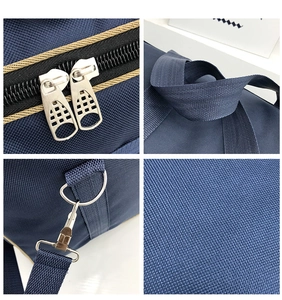 Detail view of durable metal zippers and woven handles on a large nylon travel duffel bag