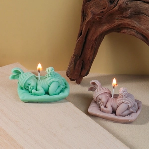 Sleeping baby aromatic candles in mint green and dusty pink with knit hat texture