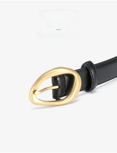 Detail of solid alloy gold buckle and high-quality black leather belt with fine texture