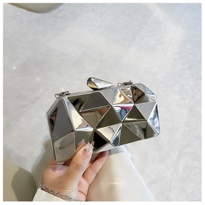 Macro view of silver geometric acrylic clutch showing polished triangular 3D facets