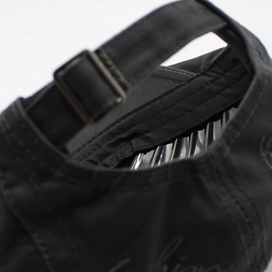 Detail of adjustable metal buckle and fashion embroidery on black cotton flat cap