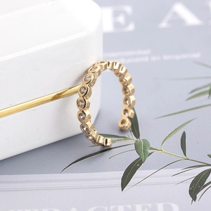 Adjustable gold plated open ring with sparkling round cubic zirconia stones on white box