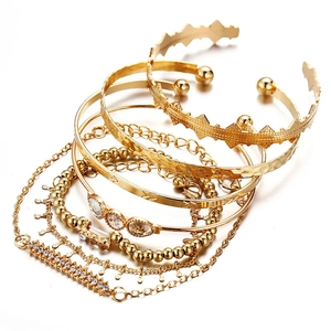 Detail eines 7-teiligen goldenen Boho-Armbandsets mit strukturierten und Perlendesigns