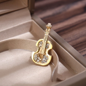 Close-up of luxury gold violin brooch with sparkling rhinestones in a gift box