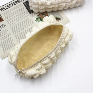Macro view of cream white quilted bubble fabric texture and zipper on the pouch