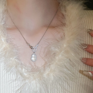 Detail of silver gourd pendant necklace with sparkling zircons on a model's neck