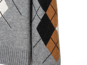 Macro della trama in maglia a rombi con bordo a coste su un maglione classico