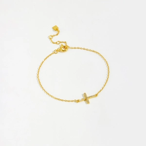 Macro detail of gold S925 sterling silver cross bracelet featuring sparkling zircon stones