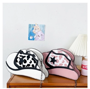 Detail view of denim hat shaped shoulder bags in pink and white with star patterns