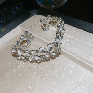 Macro detail of silver-toned flower bracelet with sparkling clear crystals on jewelry tray