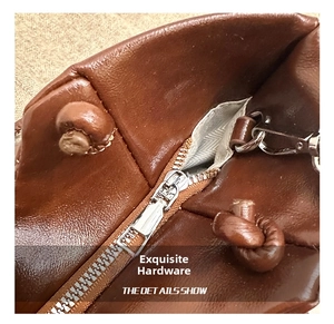 Macro detail of silver metal zipper and dark brown leather texture with herringbone lining