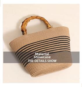 Detail showing the natural bamboo handle and black striped straw woven texture of the bag
