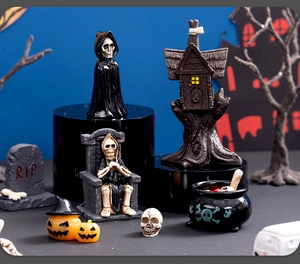 Miniature Halloween resin scene with skeleton in robes and a cauldron on dark background