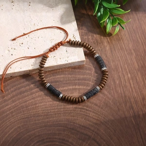 Detail of handmade adjustable beaded bracelet with hematite and turquoise on wood surface