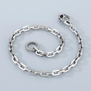 Detail of punk silver square link wallet chain featuring a skull clasp and textured ring