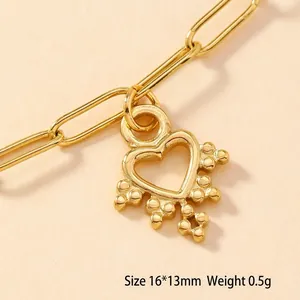 Detailed macro view of a 16x13mm hollow gold heart pendant on a paperclip chain