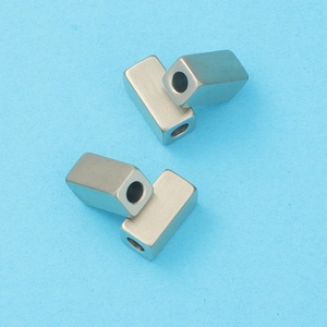 Macro view of four silver matte rectangular spacers with central holes for DIY jewelry