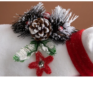 Detail shot of white plush base with pine cones, red berries and green pine branches