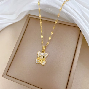 Close-up of golden bear pendant with sparkling cubic zirconia on a luxury jewelry box