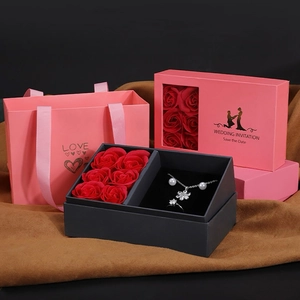 Coffret cadeau bijoux avec six roses rouges, collier de perles et bague dans un sac rose