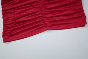 Détail du tissu froncé sur une robe rouge sexy sans manches à coupe moulante