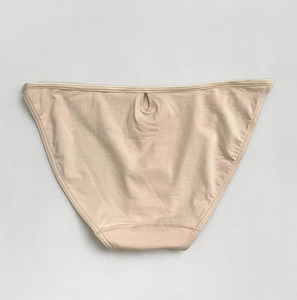 Close-up of beige cotton bikini briefs showing breathable fabric texture and elastic waistband