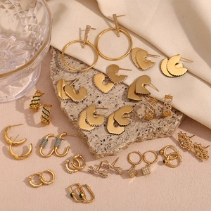 Collection of 18K gold plated C-shaped and heart earrings on light stone and silk