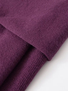 Macro view of high-quality dark purple knitwear featuring ribbing and cashmere texture