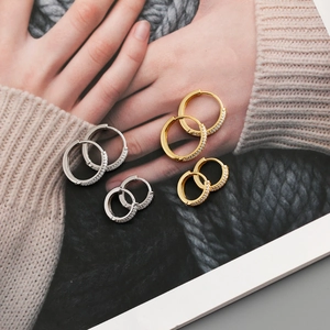 Detail of s925 silver hoop earrings with cubic zirconia in gold and silver finishes