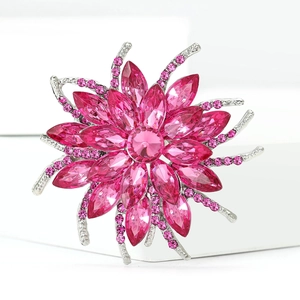 Macro shot of silver alloy flower brooch with rose pink crystal petals and silver details