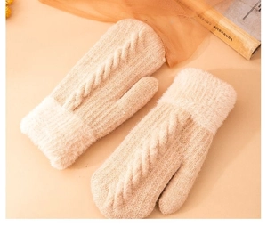 Dettaglio di muffole in maglia beige con polsini in peluche e caldo motivo a trecce