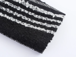 Detailed macro view of black and white striped boucle knit texture on a wool coat