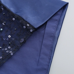 Détail du tissu en satin bleu foncé avec broderie de paillettes et de perles