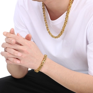 Men wearing gold stainless steel Byzantine chain necklace and bracelet set on white t-shirt