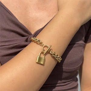 Close-up of a gold Cuban chain bracelet with a square lock pendant and OT toggle clasp