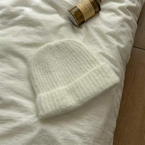 Dettaglio del berretto in lana mohair bianco crema con morbida trama a maglia