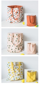 Detail view of reversible canvas tote bags in orange, peach, and lemon fruit patterns