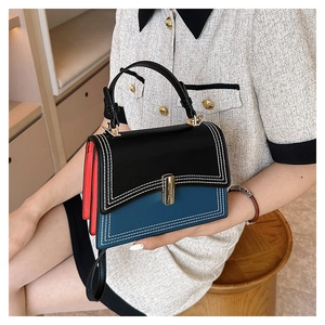 Détail d'un sac à main en cuir tricolore avec fermoir en métal et fines coutures blanches