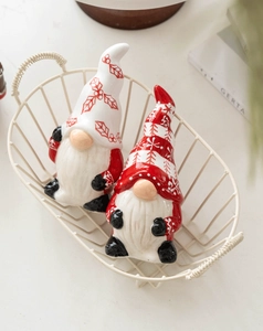 Close-up of two ceramic Christmas gnome shakers with red and white festive patterns