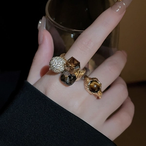 Detail of vintage gold plated rings with brown crystals and tiger eye stone on hand