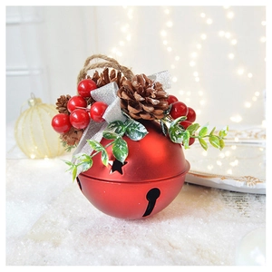 Detailed view of a red metal Christmas bell with pine cones, berries and silver ribbon