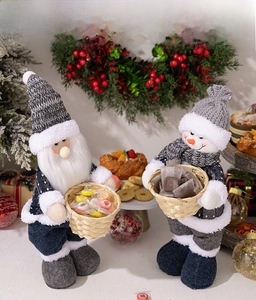 Detail of Christmas Santa and snowman plush dolls holding baskets filled with sweets