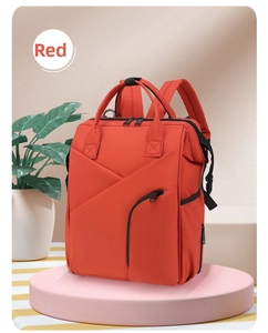 Detail of red multifunctional diaper bag with insulated milk storage pockets and wide straps