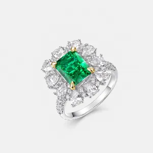 Detalle macro de un anillo con esmeralda de corte esmeralda y un halo de diamantes blancos